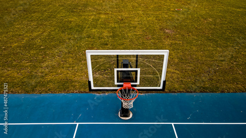 Blue Basketball court with clear hoop and grassy backkground photo