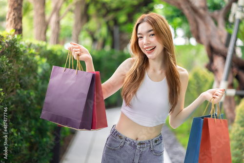 Happy woman with shopping bags enjoying in shopping. Girl holding colour paper bag.Friends walking in shopping mall.time shopping coronavirus crisis or covid19 outbreak.