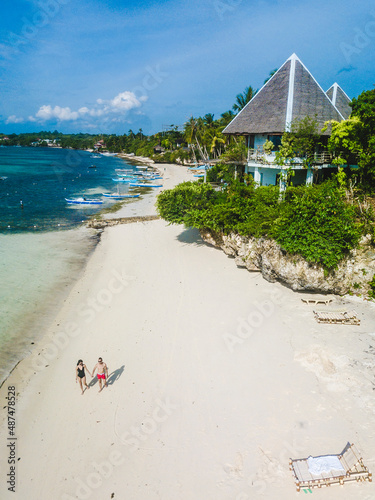 A tourist couple walks at the beach in Mithi Resort, in Dauis, Panglao Island, Bohol, Philippines. photo