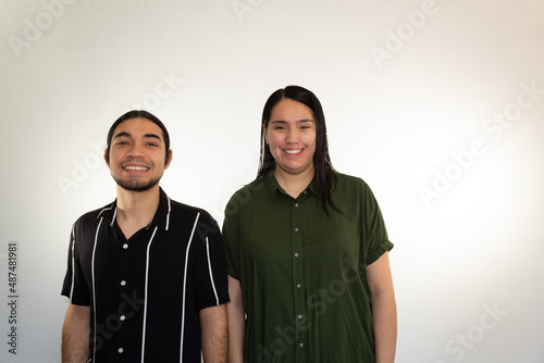 young Hispanic heterosexual couple happy and smiling on a white background