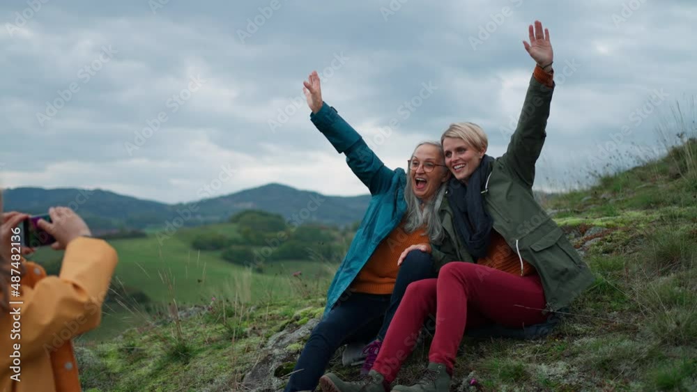 Small girl taking picture of mother and grandmother on top of mountain. Small girl taking picture of mother and grandmother on top of mountain.