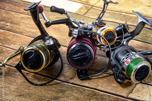 Fishing reel Fishing equipment on wooden wall background, indoors technology system