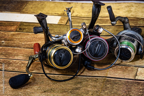 Fishing reel Fishing equipment on wooden wall background, indoors technology system