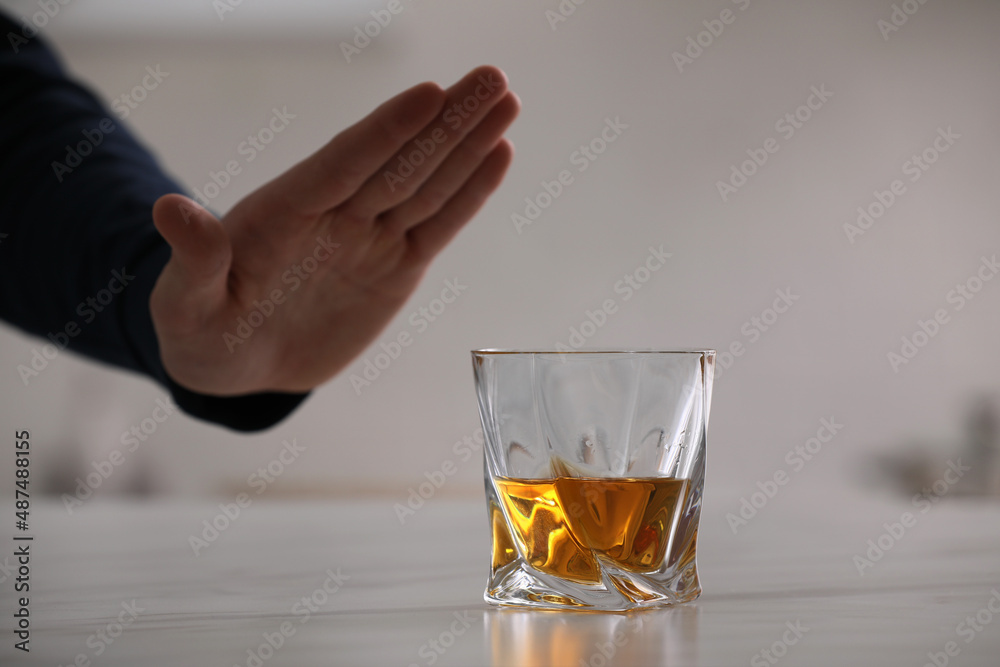 Man refusing to drink whiskey indoors, closeup. Alcohol addiction treatment Man refusing to drink whiskey indoors, closeup. Alcohol addiction treatment