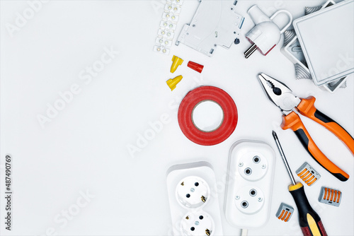 Different electrical equipment, tools on bright grey background with copy space. Top virw. Concept of repair electricity.