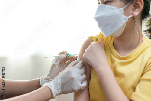 Close up of Young asian girl getting vaccinated or inoculation or Coronavirus Vaccine Injection. photo