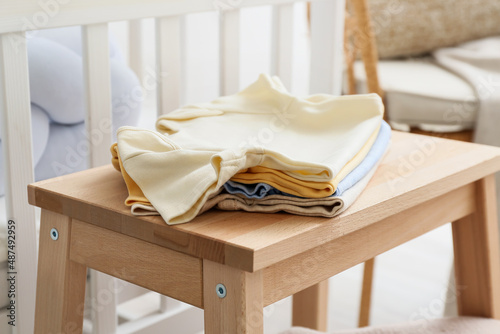 Folded baby clothes on wood...