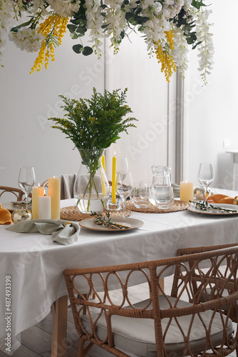 Stylish table setting with beautiful flowers in dining room