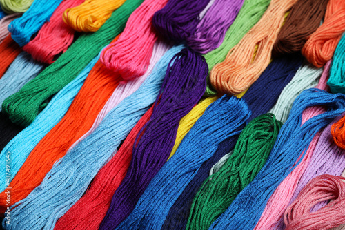 Different colorful embroidery threads as background, closeup