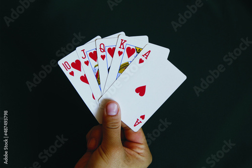 Female hand with cards from a combination of royal flush in poker