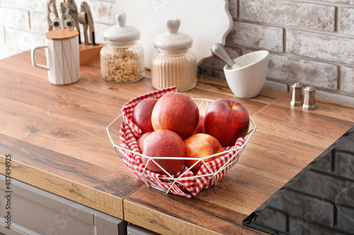 Basket with fresh apples on kitchen counter