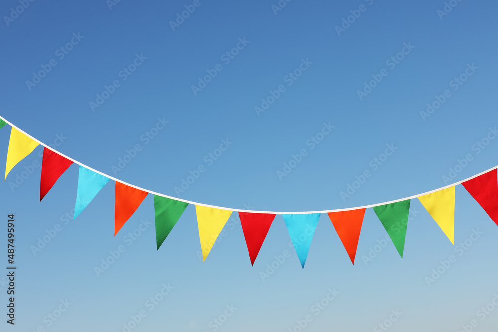 Bunting with colorful triangular flags against blue sky
