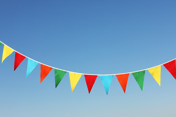 Bunting with colorful triangular flags against blue sky