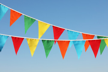 Buntings with colorful triangular flags against blue sky