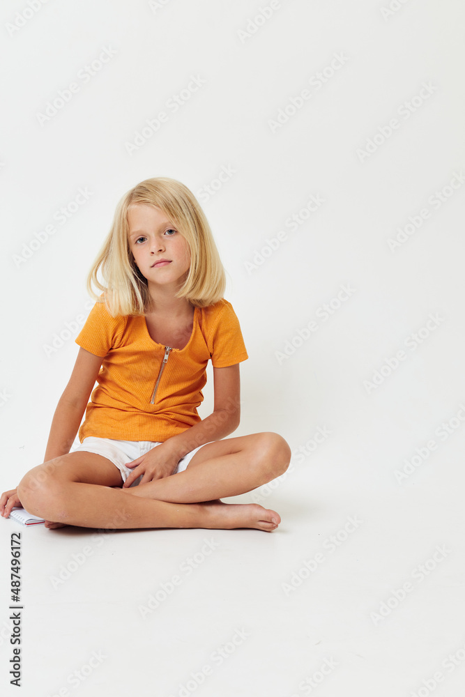 pretty girl with blond hair sitting on the floor isolated light background emotions pretty girl with blond hair sitting on the floor isolated light background emotions