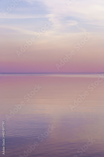 Sky background on sunset, colorful clouds. Nature abstract composition with reflections on sea water. Nature environment.