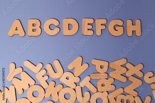 A set of wooden letters of the English alphabet on a colored background