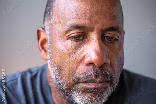 Canvas Print Portrait of a mature man looking sad with tears in his eyes.