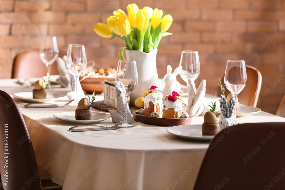 Stylish setting with Easter cakes and eggs on dining table
