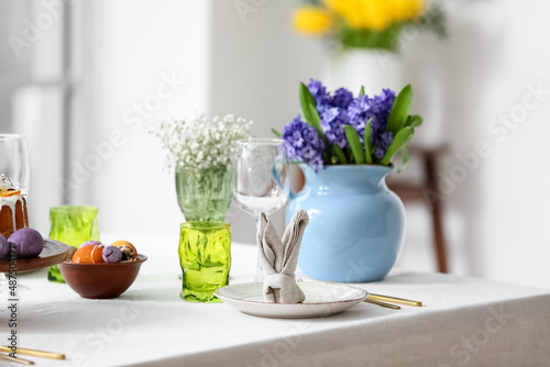 Plate with cute bunny made of napkin on table served for Easter celebration