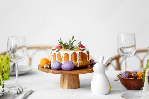 Stand with Easter cake, eggs and rabbit on served table