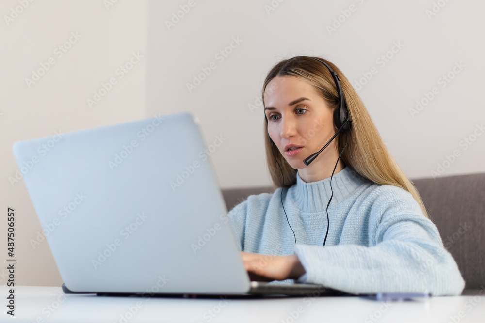 Online it support operator talking on video call. Customer care specialist wearing headset and speaking with customer. Sales manager woman calling client while wearing headphone with microphone Online it support operator talking on video call. Customer care specialist wearing headset and speaking with customer. Sales manager woman calling client while wearing headphone with microphone