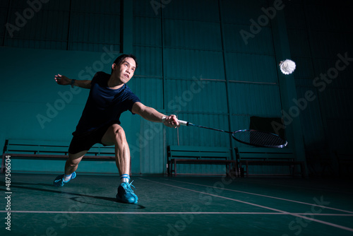 professional badminton player use racquet hit shuttle cock or shuttlecock on court during warm up play before tournament competition in single man type in indoor court