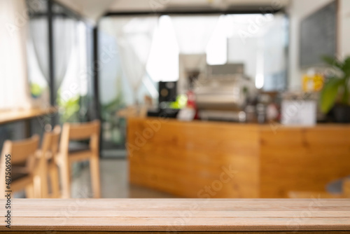 Wooden table in front of blurred background of coffee shop.