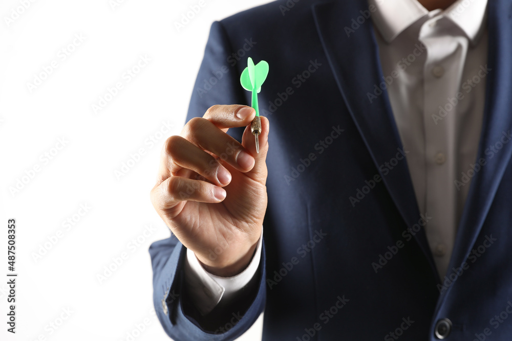 Fototapeta premium Man holding green dart on light background, closeup