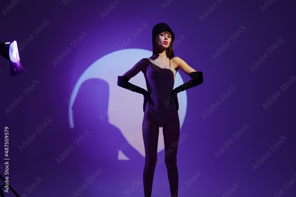 Pretty young female scene spotlight posing neon purple background unaltered