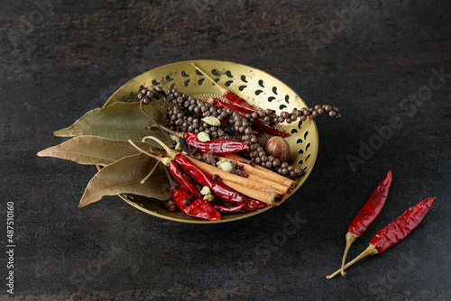 Fototapeta Naklejka Na Ścianę i Meble -  Indian spices for Indian cooking Masala hot spicy curry whole spices turmeric, cardamom, black pepper in wooden spoon curry leaves paprika in Indian spice box Kerala India Sri Lanka.