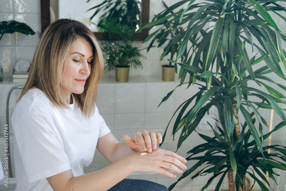 Woman smears a moisturizing hand cream on hand's skin. home body care and healthy lifestyle. Woman smears a moisturizing hand cream on hand's skin. home body care and healthy lifestyle.