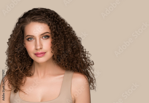 Curly long brunette hair woman beauty portrait, female glamour face. Color backgound brown