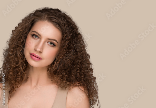 Curly long brunette hair woman beauty portrait, female glamour face. Color backgound brown