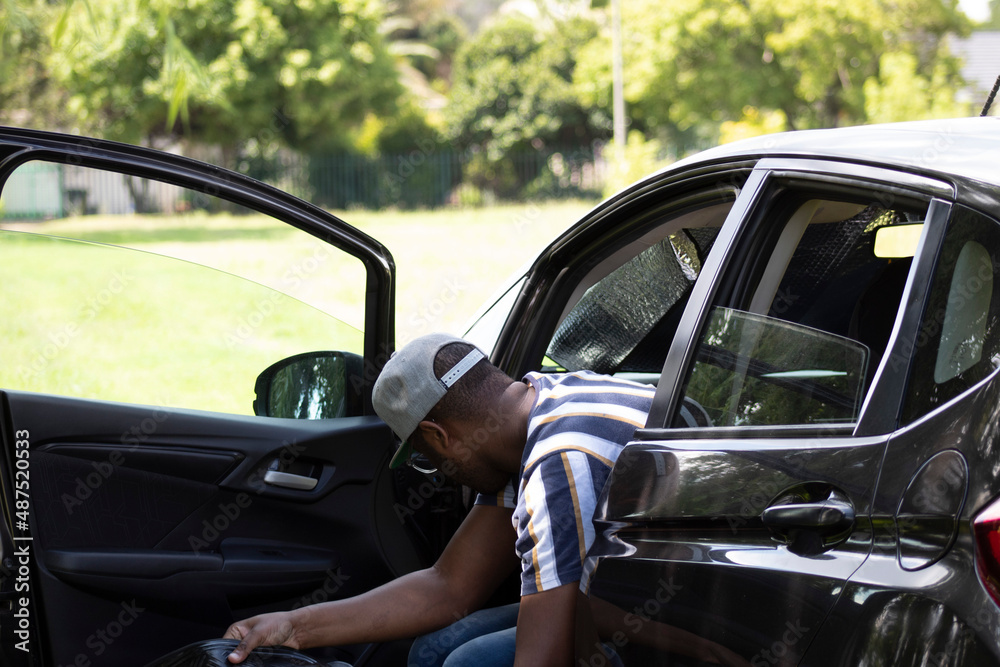 African Man cleaning his car with the door open African Man cleaning his car with the door open
