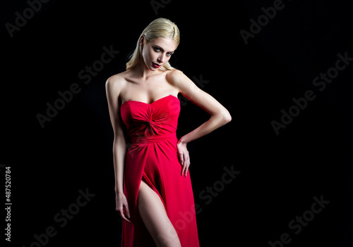 Sexy woman in red dress. High fashion portrait of young elegant woman in studio. Fashion model, beautiful young woman posing with vogue fashionable dress, studio shot.