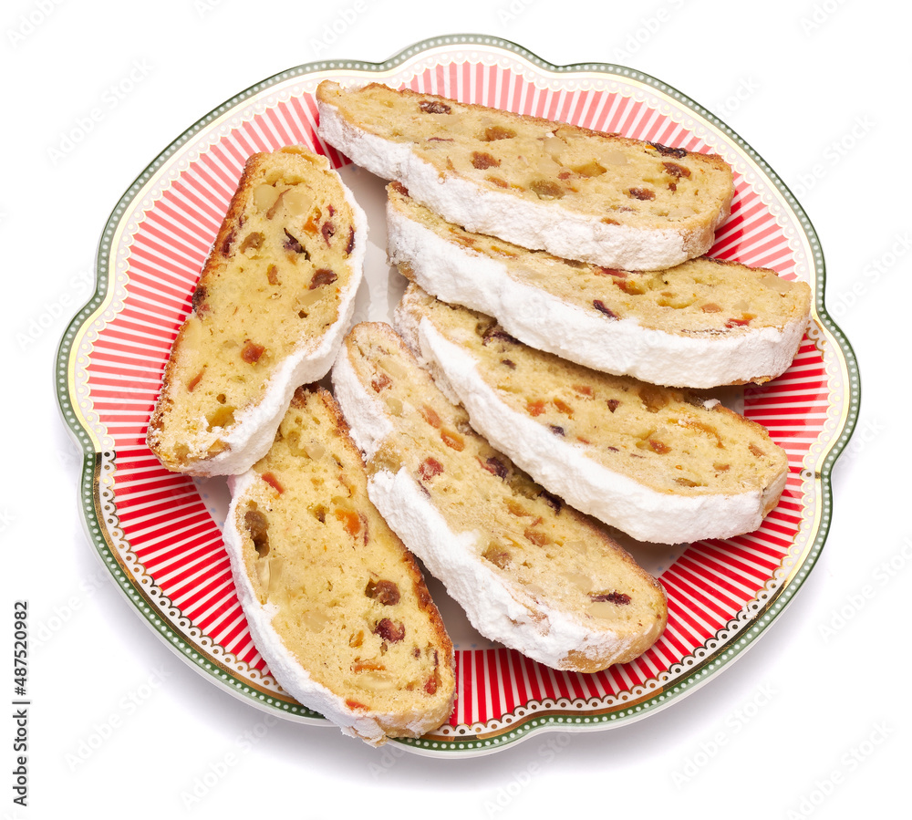 Slices of Traditional Christmas stollen cake with marzipan and dried fruit isolated on ceramic plate