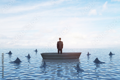 Thoughtful young businessperson on boat standing and looking at surrounding sharks. Mock up place on bright sky with clouds background. Boss and risk concept.