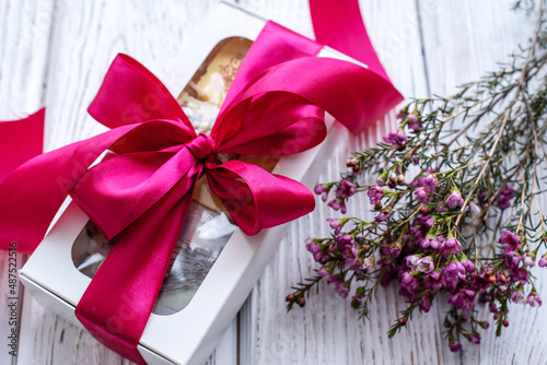 gift with a bow on a white wooden background