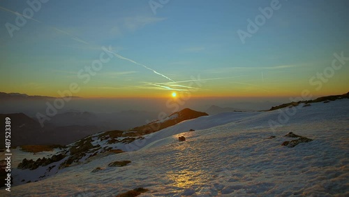 Timelaps video up in the mountains at a beautiful sunrise with mountains captured in amazing morning colors and landscape covered in snow captured in Slovenia on a mountains Ratitovec photo