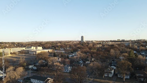 Cityscape of Bismarck, North Dakota, on a sunny day. Residential neighborhood with large office building nearby. Tree lined streets. Tall building in the distance.  photo