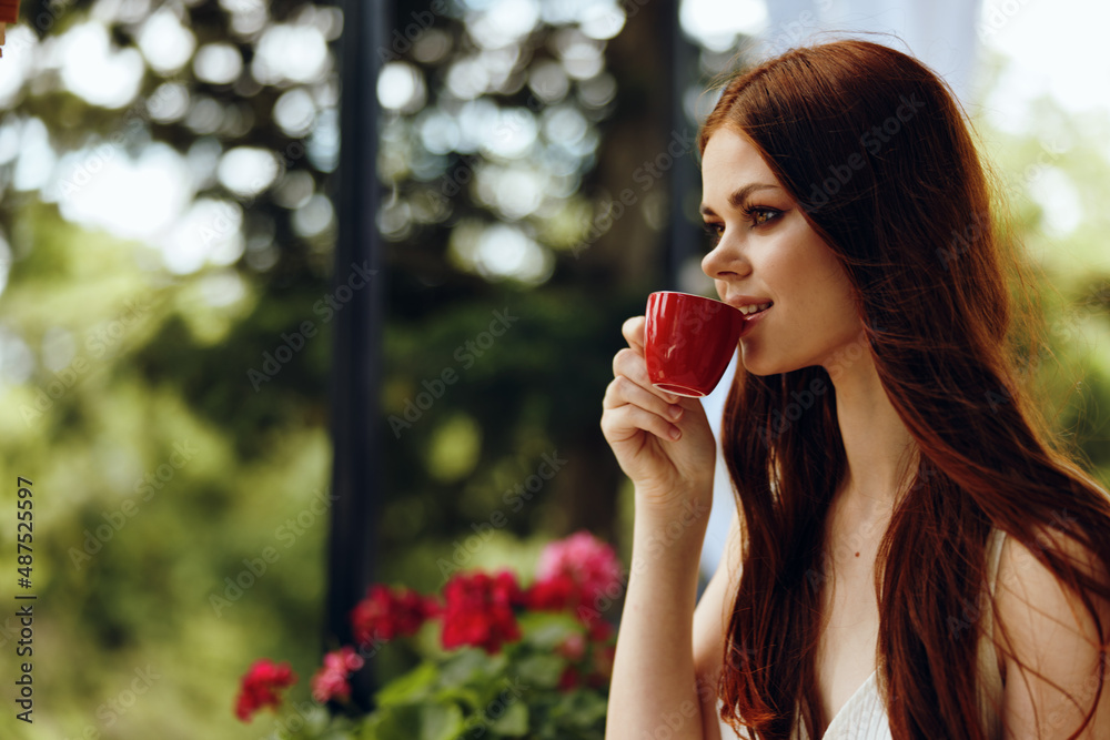 cheerful woman in a white dress drinks coffee outdoors in a cafe unaltered cheerful woman in a white dress drinks coffee outdoors in a cafe unaltered