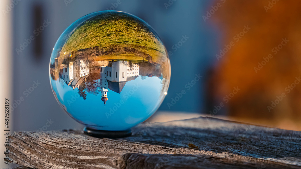 Crystal ball alpine landscape shot with a monastery at the famous Hoeglwoerther See lake, Hoeglwoerth, Bavaria, Germany