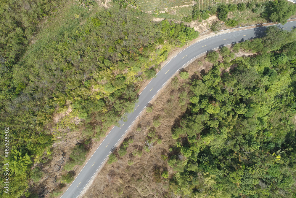 Travel on hilly road in spring aerial view road curve construction up to mountain Amazing top down image from drone camera