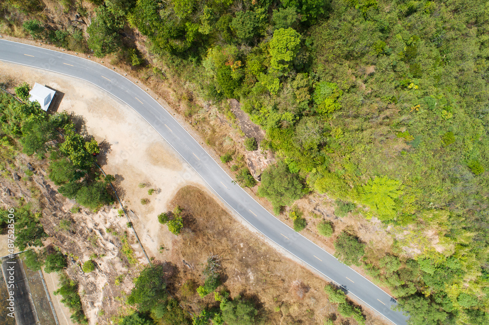 Travel on hilly road in spring aerial view road curve construction up to mountain Amazing top down image from drone camera