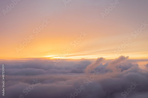 intense fabulous sunrise over clouds in warm colors, view from the plane © yelantsevv