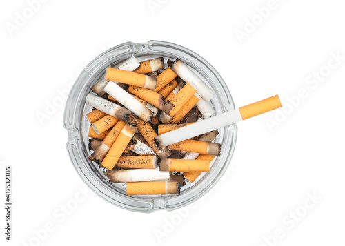 Glass ashtray full of cigarette stubs isolated on white, top view photo