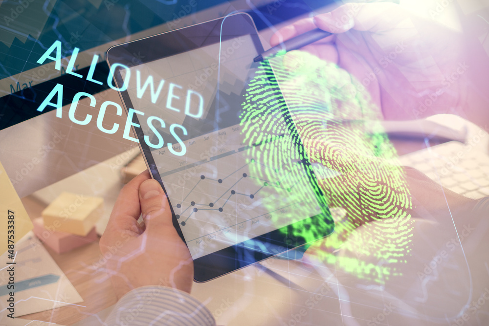 Double exposure of man's hands holding and using a digital device and fingerprint hologram drawing. Security concept. Double exposure of man's hands holding and using a digital device and fingerprint hologram drawing. Security concept.
