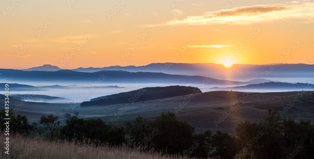 Dream landscape in the morning lights with misty mountains in the background. Nature landscape background view. First ray of light in the mountains