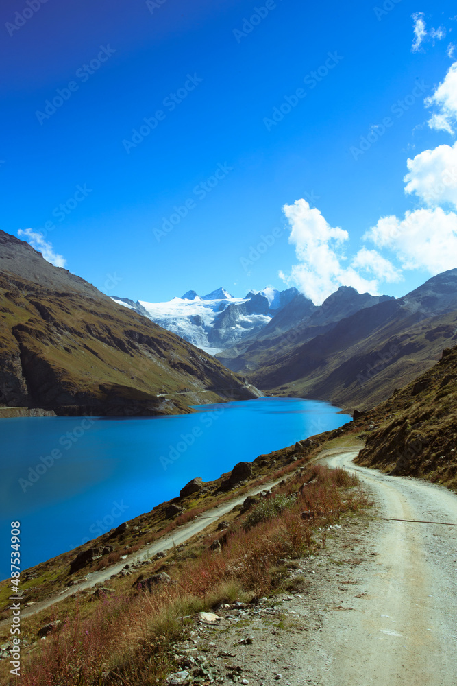 Mountain lake with road and alps in the background Mountain lake with road and alps in the background